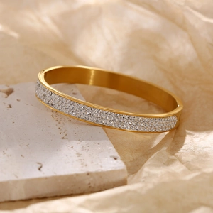 Gold plated stainless steel bangle featuring three rows of sparkling white zircons