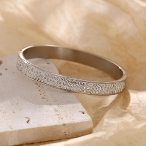 Macro detail of silver tone bangle featuring three rows of sparkling zircon stones