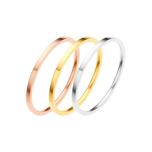 Dettaglio di tre anelli minimalisti in oro, oro rosa e argento lucido da abbinare