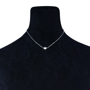 Detailed view of silver heart pendant necklace on black lace neck display mannequin