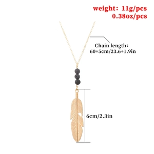 Long arrow feather pendant necklace with black lava stone beads on gold chain