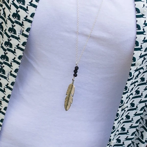 Long arrow feather pendant necklace with black lava stone beads and antique gold finish