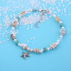 Fußkettchen mit Seestern-Anhänger, Muscheln und Türkis-Perlen auf einem sommerlichen Sandgrund