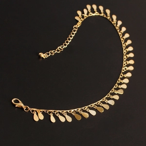 Close-up of golden teardrop pendant anklet with lobster clasp and adjustable extension chain