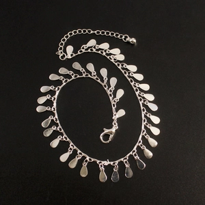 Detailed view of silver beach anklet with dense teardrop pendants and lobster clasp closure