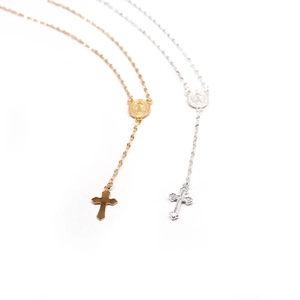 Detail of gold and silver Virgin Mary rosary necklaces with polished cross pendants