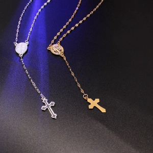 Macro shot of gold and silver cross necklaces with religious medals on textured background