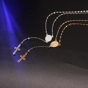 Close-up of gold and silver religious cross pendants with St. Benedict medals on chains