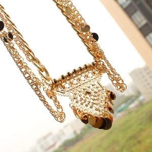 Detailed close-up of golden multilayer waist chain with bohemian sequins and镂空 hollow charms
