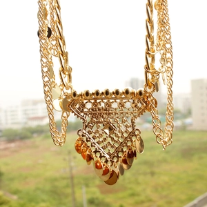 Detail of layered gold bohemian waist chain with triangle pendant and sequins