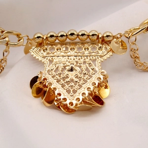 Detail of bohemian gold waist chain featuring hollow filigree and sequin tassels