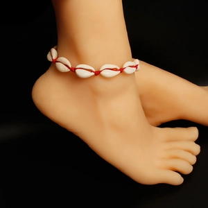 Handgemaakte enkelband met witte kauri schelpen en rood geweven touw voor strandvakanties