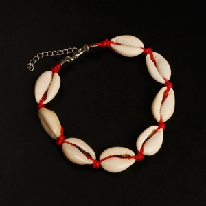 Detailweergave van de handgemaakte schelpen enkelband met rood koord en sluiting