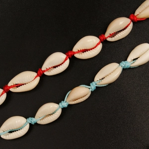 Macro-opname van handgemaakte enkelbandjes met natuurlijke schelpen en gekleurd touw op zwart