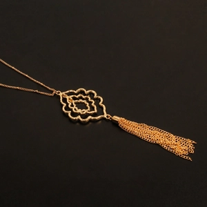 Detalle de los pétalos huecos dorados con textura martillada y borla de cadena metálica