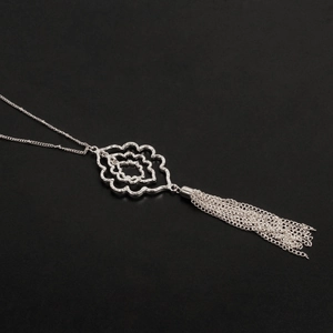 Detalle de colgante floral geométrico con borlas largas de metal plateado estilo boho