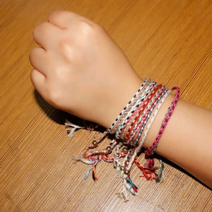 Bohemian hand-woven friendship bracelets with gold beads on wrist in a set of multiple colors