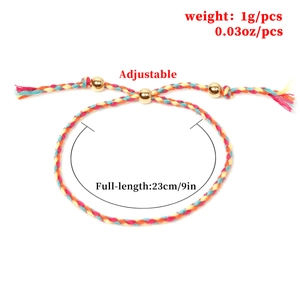 Adjustable handmade braided rope bracelet with three gold beads on white background