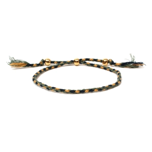Detailed view of handmade woven friendship bracelet with gold beads and tassels