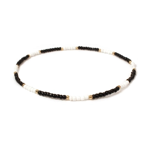 Detailed close-up of handmade minimalist beaded necklace with black, white and gold beads
