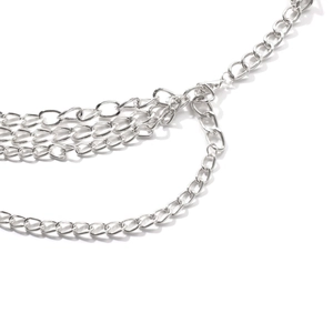 Macro shot of silver multi-layer punk chain body jewelry with lobster clasp details