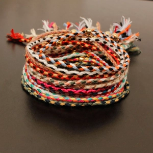 Handmade braided multi-colored cord bracelet with gold metal beads and tassels