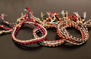 Macro detail of handmade colorful woven friendship bracelets with polished gold metal beads