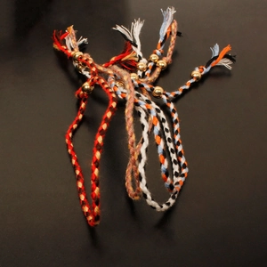 Close-up of handmade bohemian woven bracelets with gold beads and tassel ends