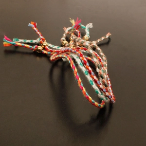 Detail of colorful woven bohemian bracelets featuring vibrant threads and gold beads