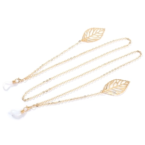 Detail view of gold glasses chain featuring delicate leaf pendants and silicone connectors