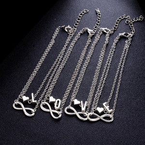 Dettaglio di cavigliere in argento con cuore e infinito e pendenti con lettere L-O-V-E