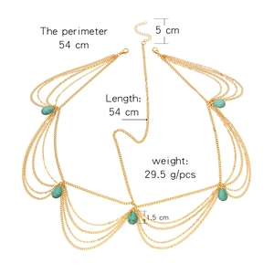 Multilayer gold chain body jewelry with turquoise teardrop pendants on white background