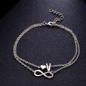 Cavigliera doppia in argento con cuore, lettera V e simboli infiniti su fondo nero
