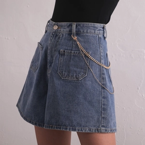 Minimalist double-layered metal body chain on blue denim shorts for a punk aesthetic