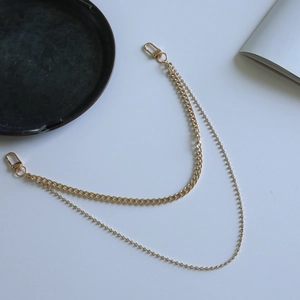 Detail of a dual-layer gold chain with sparkling rhinestones and lobster clasps