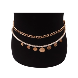 Detailed macro view of double-layered pearl and gold coin chain body jewelry on waist