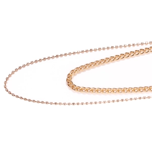 Detail of dual-layer gold body chain featuring chunky Cuban links and sparkling rhinestones
