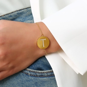 Detailed view of an adjustable gold letter T pendant bracelet with sparkling cubic zirconia