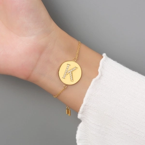 Adjustable gold stainless steel bracelet featuring a zircon-inlaid letter K pendant