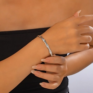 Detail showing wavy silver bangle with tiny zircons on a model's wrist for a sleek look
