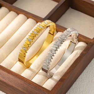 Bracelet jonc en acier titane avec feuilles en zircone dorées et argentées sur velours