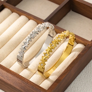 Bracelet étoile en acier titane poli avec zircons, finitions en or 18 carats et argent