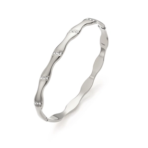 Macro shot of silver wavy bangle with small rhinestones and polished metal finish