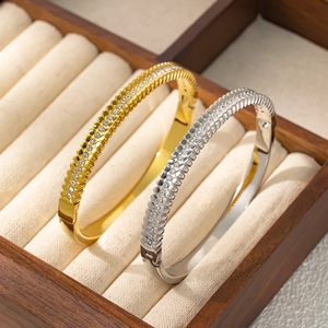 Brazaletes de acero inoxidable en oro y plata con diamantes de imitación en joyero de madera