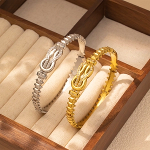 Detailed view of gold and silver knot bracelets featuring micro-pave crystals and textures