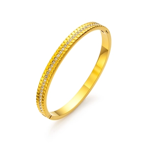 Elegante brazalete de acero de titanio chapado en oro con una hilera de circonitas cúbicas
