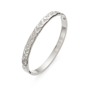 Detalle de brazalete de acero plateado con textura de celosía y piedras de circonia incrustadas