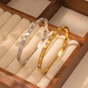 Polished 18K gold and silver stainless steel nail bracelets with zircon on velvet display
