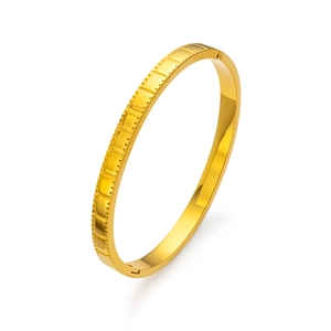 Bracelet jonc en acier doré avec motifs géométriques gaufrés et finition polie