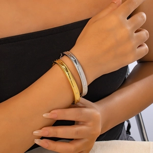 Gros plan de bracelets superposés en or et argent avec bords perlés et diamants fins